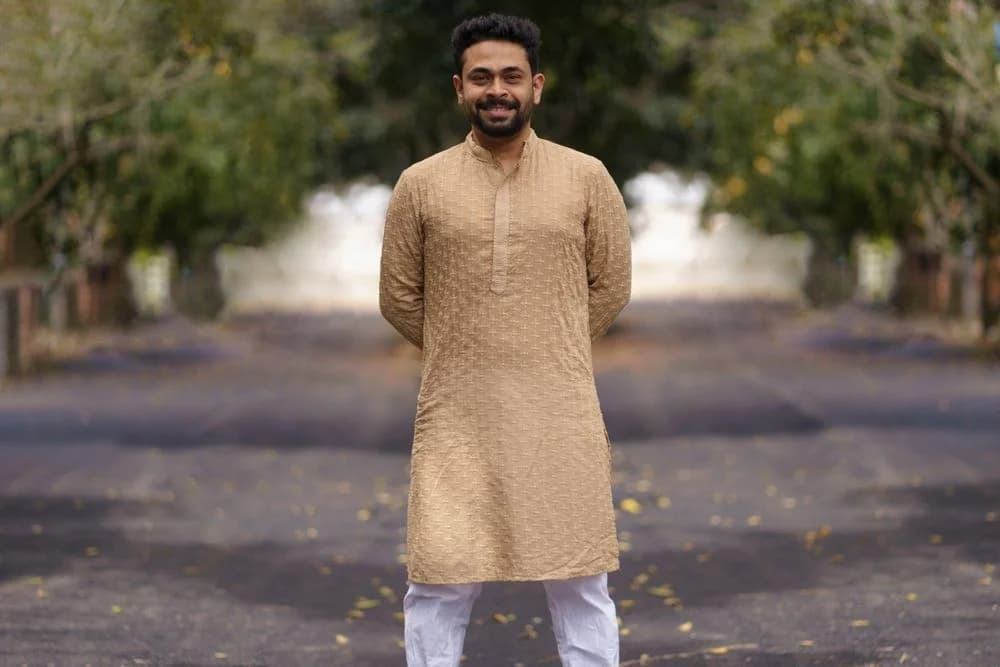Man wearing an embroidered beige kurta outdoors